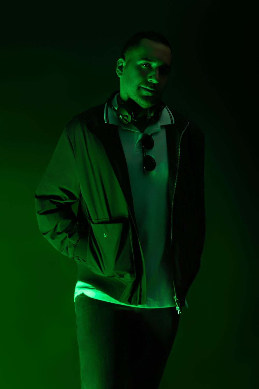 Pullär in green light, headphones around his neck